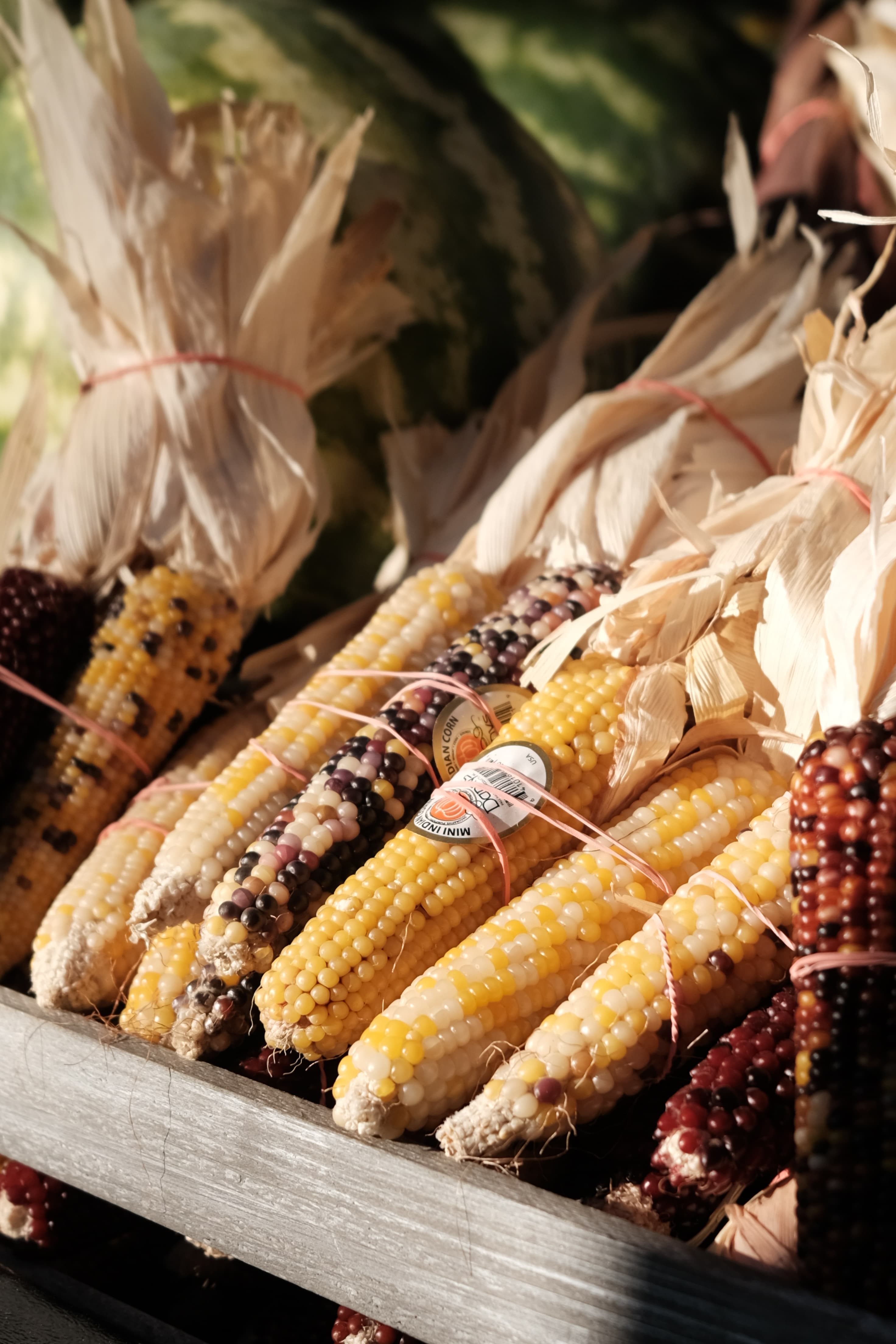 Corn in a wooden crate at a farmers' market